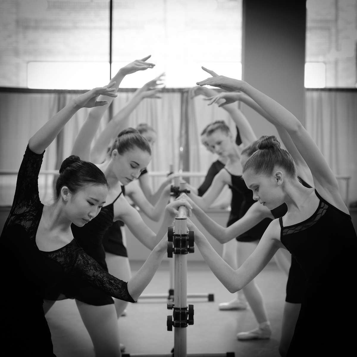 Four young ballet dancers at the barre in black and white, Spokane dance studio portrait