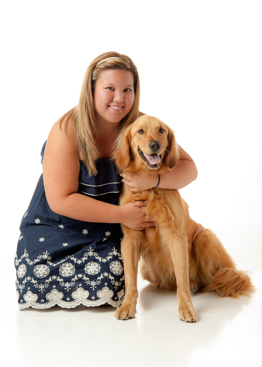 High school senior girl posing with a golden retriever in a white studio, Spokane senior portraits