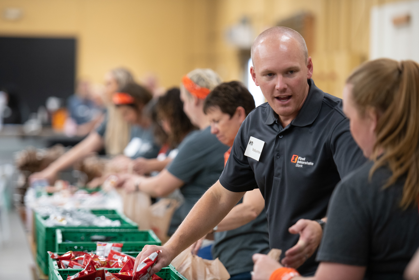 Team of employees in matching company polo shirts working together at a community volunteer event — corporate and team photography in Spokane, WA by Scott Martinez